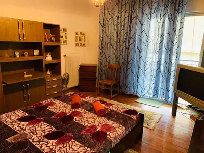 a bedroom with a bed with red flowers on it at House Mario’s airport 2 in Spáta
