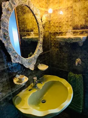 a bathroom with a yellow sink and a mirror at House Mario’s airport 2 in Spáta