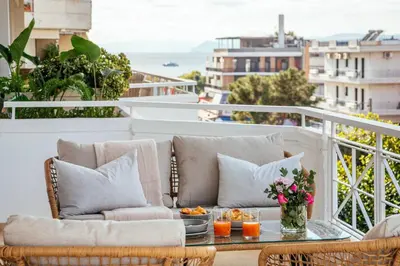 a balcony with a couch and a table with flowers at 2-BDR SV Elegance Luxury Apt with Shared pool in Athens