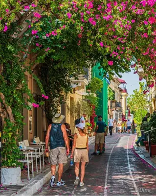 a group of people walking down a street with flowers at Syntagma studio in Athens