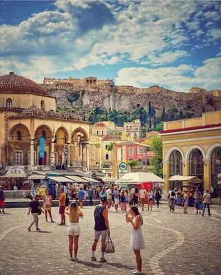 a group of people walking around a city with a mountain at Syntagma studio in Athens