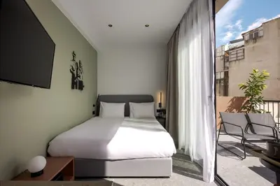 a bedroom with a bed and a balcony with a tv at Bonnie Athens by Nin&Bau in Athens