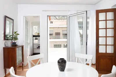 a white dining room with a white table and chairs at zen penthouse in exarchia in Athens