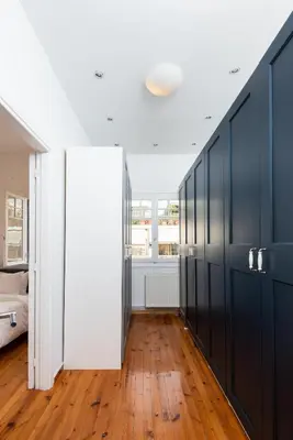 a hallway with black cabinets and a bed in a room at zen penthouse in exarchia in Athens
