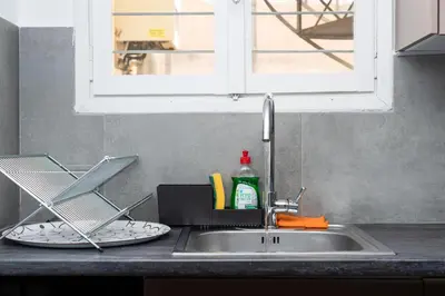 a kitchen counter with a sink and a window at zen penthouse in exarchia in Athens