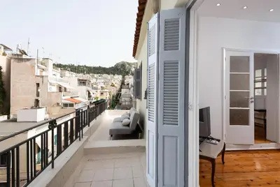 a balcony with a couch and a television on a building at zen penthouse in exarchia in Athens
