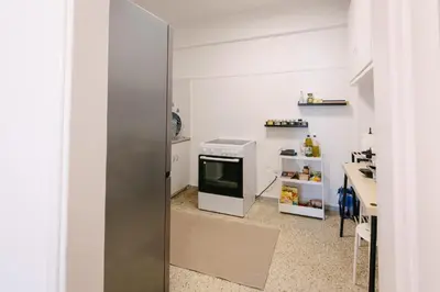 a kitchen with a refrigerator and a counter with a table at ZEN Sofokleous in psiri in Athens