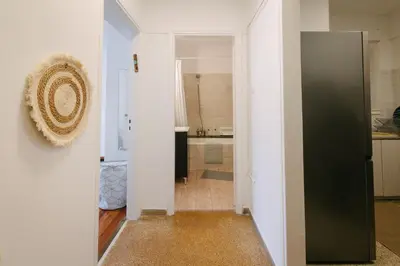 a hallway leading to a kitchen with a black refrigerator at ZEN Sofokleous in psiri in Athens