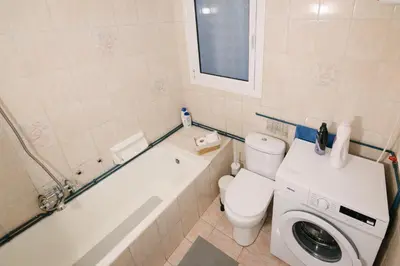 a bathroom with a toilet and a tub and a washing machine at ZEN Sofokleous in psiri in Athens