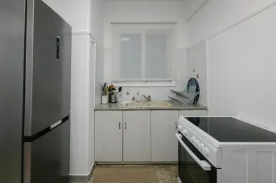 a white kitchen with a sink and a refrigerator at ZEN Sofokleous in psiri in Athens