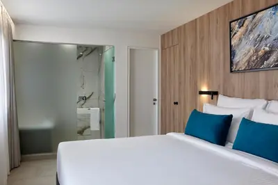 a bedroom with a white bed and blue pillows at Hestia - Kolokotroni 23 in Athens