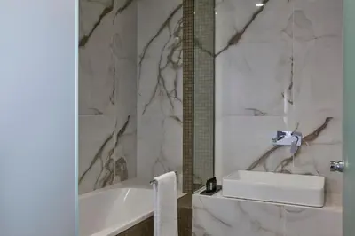 a bathroom with a white tub and a sink at Hestia - Kolokotroni 23 in Athens