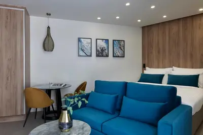 a hotel room with a blue couch and a bed at Hestia - Kolokotroni 23 in Athens