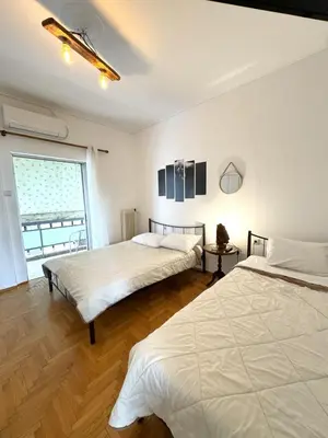 a bedroom with two beds and a window at An Athenian Gem by the Acropolis in Athens