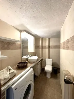 a bathroom with a toilet sink and a washing machine at An Athenian Gem by the Acropolis in Athens