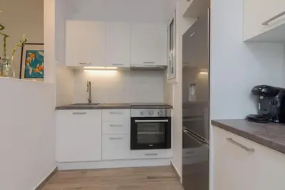 a kitchen with white cabinets and a black oven at The Acropolis dream house in Athens
