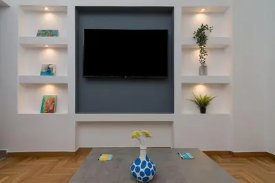 a living room with a tv and a vase on a table at The Acropolis dream house in Athens