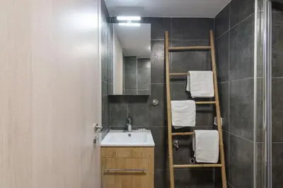 a bathroom with a sink and a shelf with towels at The Acropolis dream house in Athens