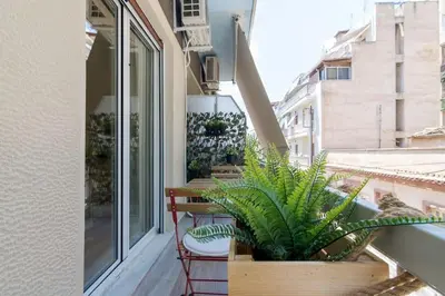a balcony with chairs and plants on a building at The Acropolis dream house in Athens