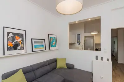 a living room with a couch and some pictures on the wall at The Acropolis dream house in Athens