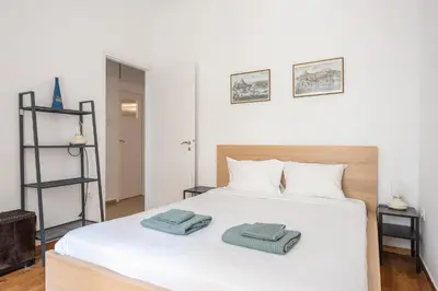 a bedroom with a white bed with two towels on it at Zen Exaricha in Athens