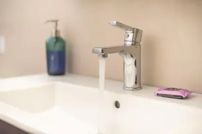 a sink with a faucet and a bottle of soap at Zen Exaricha in Athens