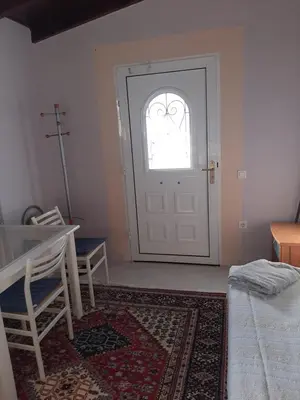 a room with a door and a table and a rug at Suburbs Georgia's loft in country side 15' from the Airport in Paianía