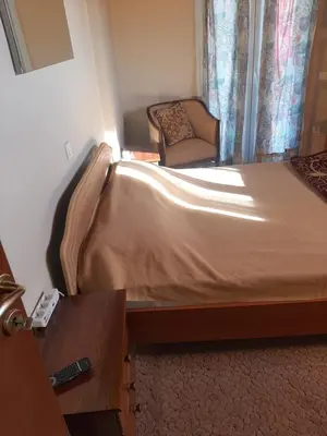 a bedroom with a bed and a chair in it at Suburbs Georgia's loft in country side 15' from the Airport in Paianía