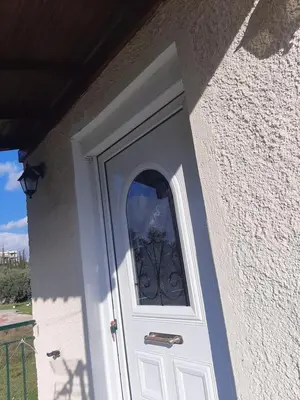 a white door with a window on a building at Suburbs Georgia's loft in country side 15' from the Airport in Paianía
