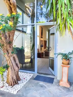 a palm tree in front of a house at Varkiza Minimal Residence-5minSea in Vari