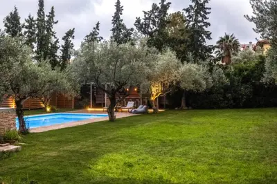 a backyard with a swimming pool and trees at Varkiza Minimal Residence-5minSea in Vari