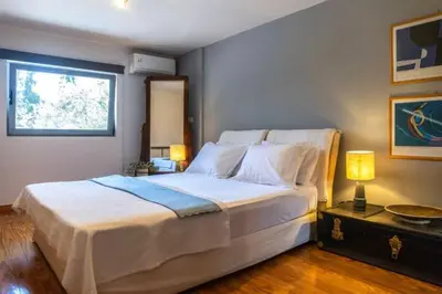 a bedroom with a large white bed with a window at Varkiza Minimal Residence-5minSea in Vari
