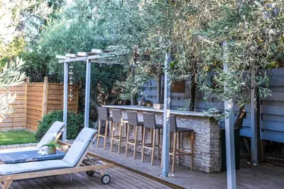 a backyard patio with a bar and a table and chairs at Varkiza Minimal Residence-5minSea in Vari