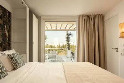 a bedroom with a bed and a large window at Rooftops of Athens - Areos Studio Jacuzzi & View in Athens
