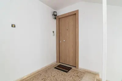 a room with a wooden door and a rug at VARKIZA APARTMENT in Varkiza