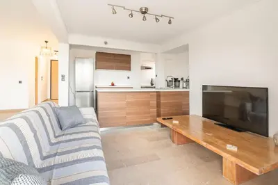 a living room with a couch and a large television at VARKIZA APARTMENT in Varkiza