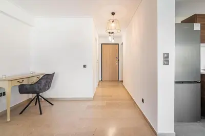 a kitchen with a desk and a hallway with a door at VARKIZA APARTMENT in Varkiza