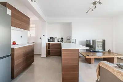a kitchen with wooden cabinets and a counter top at VARKIZA APARTMENT in Varkiza