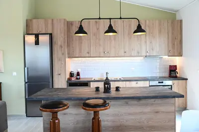 a kitchen with a counter and two bar stools at Αθηναϊκή Ριβιέρα in Anavissos