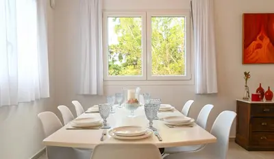 a dining room with a white table and white chairs at Αθηναϊκή Ριβιέρα in Anavissos