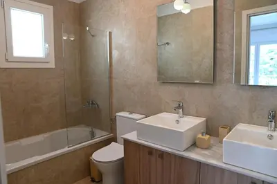 a bathroom with a sink and a toilet and a mirror at Αθηναϊκή Ριβιέρα in Anavissos