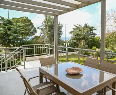 a dining room with a glass table and chairs at Αθηναϊκή Ριβιέρα in Anavissos