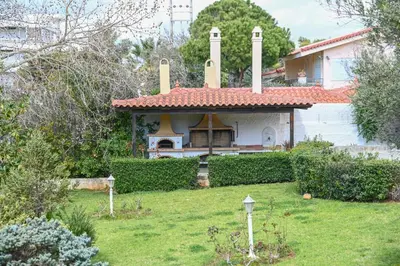 a house with a chimney on top of a yard at Αθηναϊκή Ριβιέρα in Anavissos
