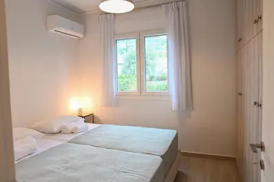 a bedroom with two beds and a window at Αθηναϊκή Ριβιέρα in Anavissos