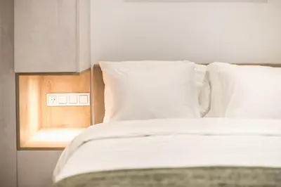 a bed with white sheets and pillows in a room at Newly Renovated Escape/Psychiko in Athens