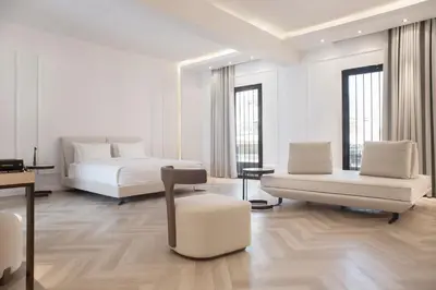 a white room with two beds and a chair at Maison7 - Acropolis in Athens