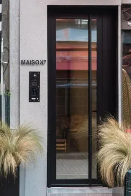a glass door of a restaurant with two potted plants at Maison7 - Acropolis in Athens