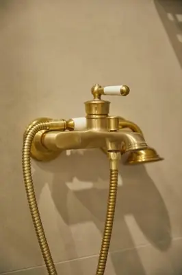 a brass shower faucet with a hose at The sunny house in Athens