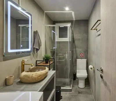 a bathroom with a large stone sink and a toilet at The sunny house in Athens