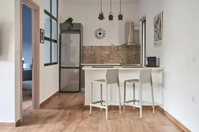 a kitchen with a white counter and stools at The sunny house in Athens